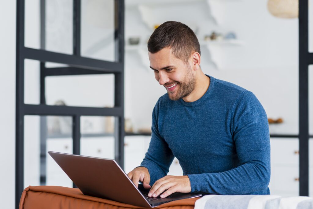 homme-souriant-travaillant-ordinateur-portable-maison (1)